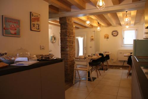 cocina y comedor con mesa y sillas en b&b Due Perle, en Chioggia