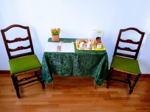 einen Tisch mit 2 Stühlen und einem grünen Tischtuch in der Unterkunft Casa Favaretto Guest House in Venedig