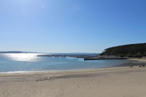 a sandy beach with a pier in the water at L'Imprenable vue mer in Crozon