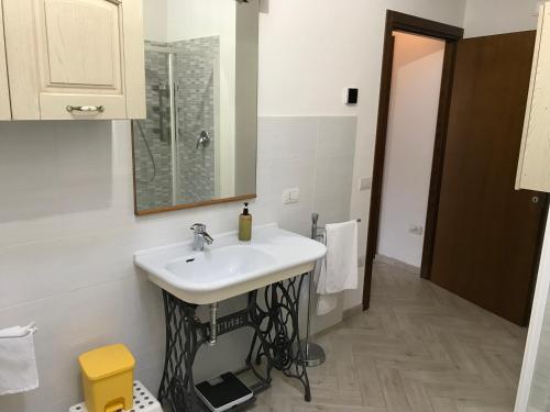 W łazience znajduje się biała umywalka i lustro. w obiekcie Alle case il pozzetto w mieście Suvereto