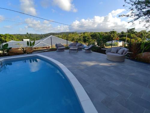 a swimming pool with lounge chairs on a patio at villa Lorenza in Petit-Bourg