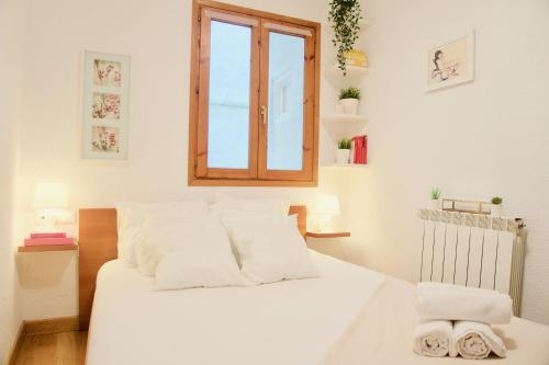 a bedroom with a white bed with a window at TOP APARTMENT frente a la Catedral in Pamplona