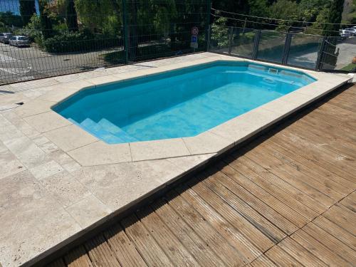 une petite piscine avec une terrasse en bois dans l'établissement CAVALIERE APT 125M2 PISCINE, au Lavandou