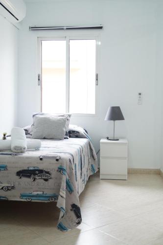 Habitación blanca con cama y ventana en Sol Centro Apartment A, en Sevilla