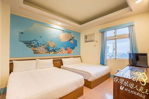 um quarto de hotel com duas camas e um mural de peixe em Blue Sea Romance B&B em Ilha Verde