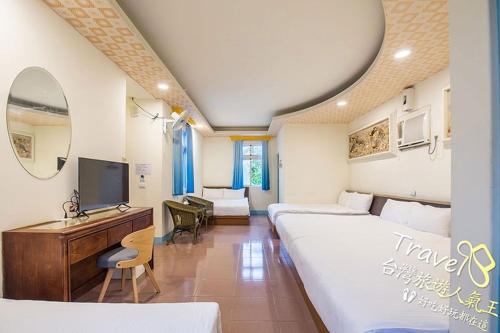 Habitación de hotel con 2 camas, escritorio y TV. en Blue Sea Romance B&B, en Isla Verde