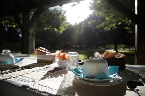 un tavolo con teiera, tazze e piatti di Rive Gauche - Chambres d'hôtes en bord d'Authion a Mazé