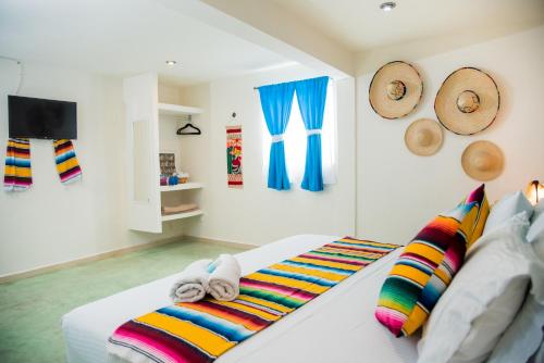 a bedroom with a bed with colorful blankets and pillows at Hidalgo Boutique Rooms in Isla Mujeres