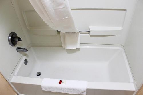 a white bath tub in a bathroom with a towel at Baymont by Wyndham Springfield in Springfield