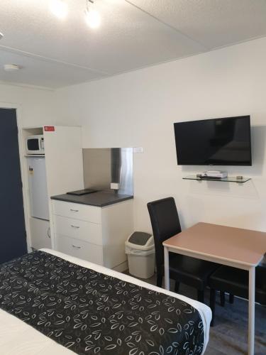 a small room with a table and a kitchen with a desk at Budget on the Lake in Hamilton
