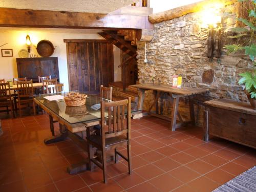 a dining room with a table and a stone wall at Casa da Bica Gondesende in Bragança
