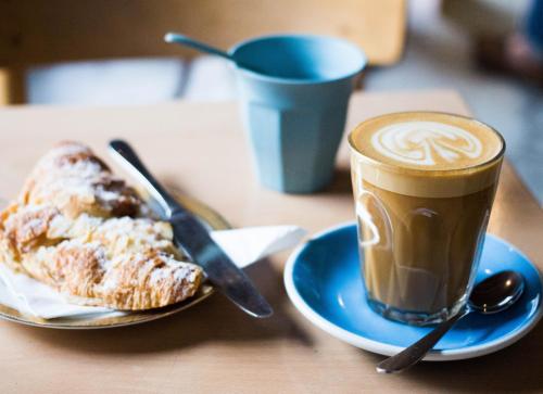 a cup of coffee and a pastry on a table at Novotel Melbourne On Collins in Melbourne