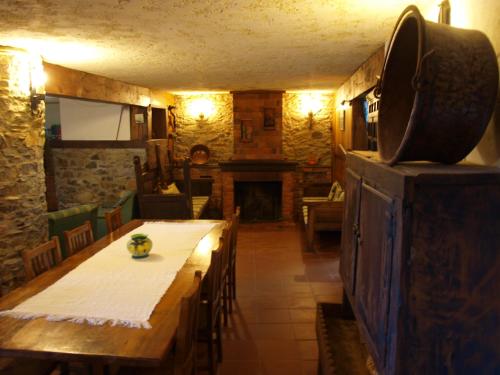 a dining room with a table and a fireplace at Casa da Bica Gondesende in Bragança