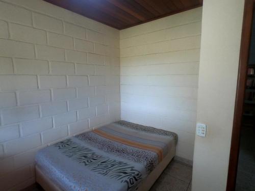 um pequeno quarto com um colchão no canto em CASA AMARELA Beira Rio Guriri em Guriri