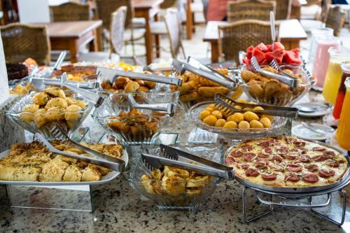 a table with many different types of food on it at Fragata Apart Hotel in Florianópolis