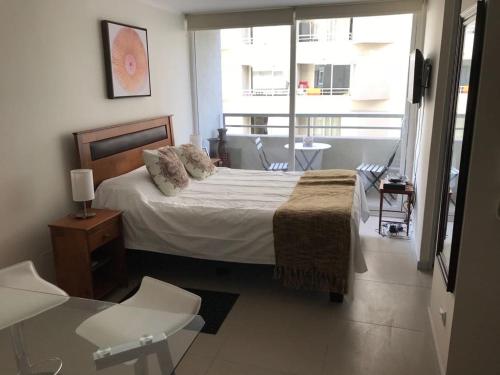 une chambre avec un lit et une grande fenêtre dans l'établissement Nuevo departamento Moneda, à Santiago