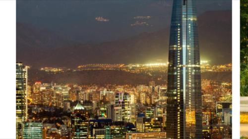 - une vue sur une ville la nuit avec un haut gratte-ciel dans l'établissement Nuevo departamento Moneda, à Santiago