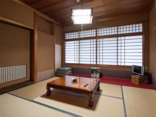 a living room with a table and a tv at Koyasan Shukubo Sainanin in Koyasan