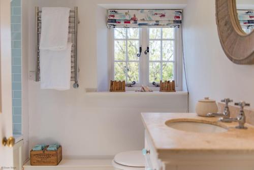 La salle de bains est pourvue d'un lavabo et d'une fenêtre. dans l'établissement Hill House Farm by Bloom Stays, à Canterbury