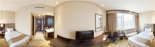 a hotel room with two beds and a television at Holiday Inn Mudanjiang by IHG in Mudanjiang