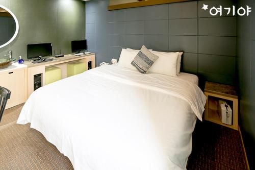 Un pat sau paturi într-o cameră la Yangsan Seoksan W Hotel
