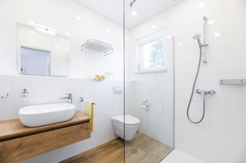 a bathroom with a sink and a toilet and a shower at Pribetic Apartments in Poreč