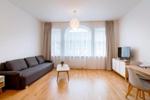 a living room with a couch and a tv at Residential Barona Apartments in Riga Centre in Rīga