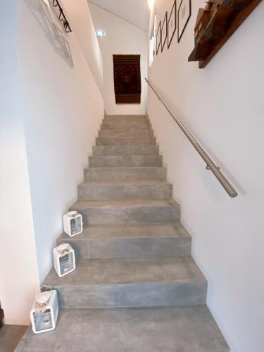 a staircase in a house with concrete floors and white walls at Antica Sosta dei Viandanti in Cadenazzo