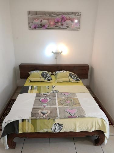 a bedroom with a bed with a quilt on it at Zoiseaux Paradis in Ravine des Cabris