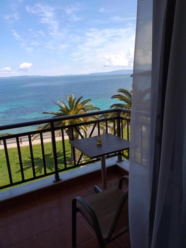 a balcony with a table and a view of the ocean at Barbagiannis House in Ormos Panagias
