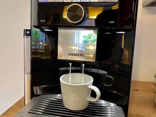 a coffee cup is being made in a microwave at Hotel Garni Dünennest in Sankt Peter-Ording