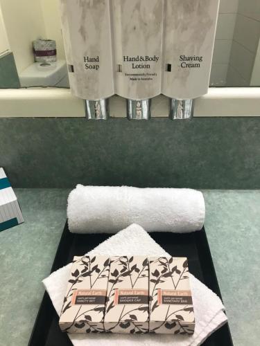 bagno con asciugamano e 2 rotoli di carta igienica di Emerald Central Hotel Official a Emerald