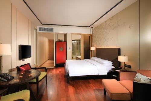 a hotel room with a bed and a living room at Hyatt Regency Chongming in Chongming