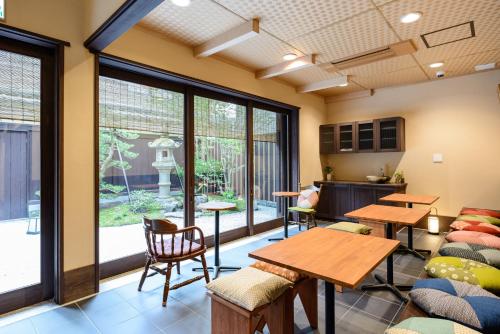 a room with tables and chairs and large windows at Luck You Kyoto in Kyoto