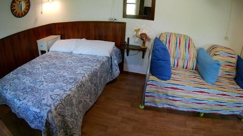 a bedroom with a bed and a chair in it at Alojamiento Rural El Brazal in Lanjarón