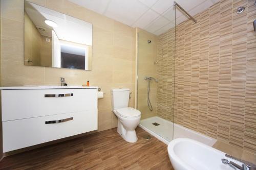 een badkamer met een toilet, een wastafel en een spiegel bij BIG FISH in La Manga del Mar Menor