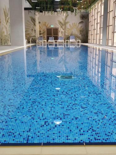 a large swimming pool with chairs in a building at Al Kout Beach Hotel in Kuwait