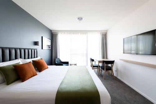 een hotelkamer met een groot bed en een tafel bij Abode Kingston in Canberra