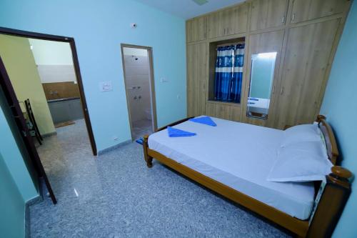 a bedroom with a bed and a large mirror at TrueLife - Railway station - On way to Balaji Temple - Breakfast included - Large 2BHK AC Apartments - Enjoy morning Coffee Tea Milk - Modular Kitchen - Fast WiFi, Jio Smart TV - Easy access to all Temples - Travels - TrueLife's service with lots of Love in Tirupati