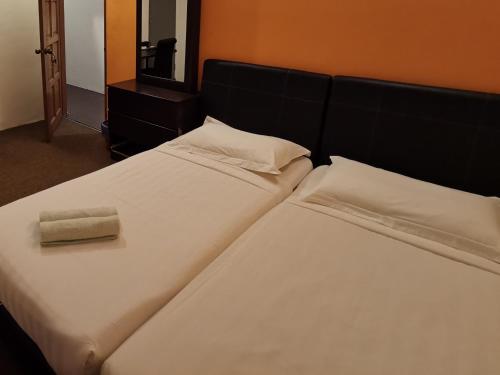 a bedroom with two beds with white sheets and a mirror at StarVilla Kinta River Front Medan Istana in Ipoh