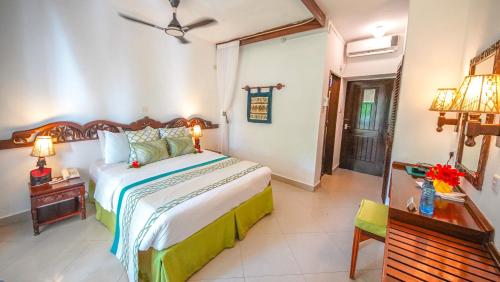 a bedroom with a bed and a table with a lamp at Papillon Lagoon Reef Hotel in Diani Beach