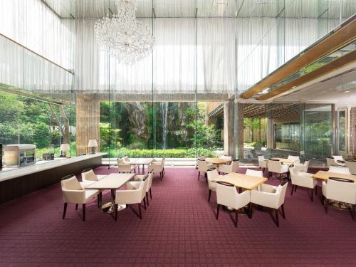 a restaurant with tables and chairs and a chandelier at Nara Royal Hotel in Nara