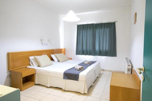 um pequeno quarto com uma cama e uma janela em DebbieXenia Hotel Apartments em Protaras