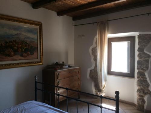 ein Schlafzimmer mit einem Bett, einem Gemälde und einem Fenster in der Unterkunft Cominium Benessere in Alvito