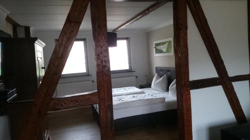 een slaapkamer met een stapelbed en 2 ramen bij Mario's fachwerkhaus am Huy in Schlanstedt