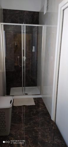 a shower with a glass door in a bathroom at B&B MONTEBELLO in Trani