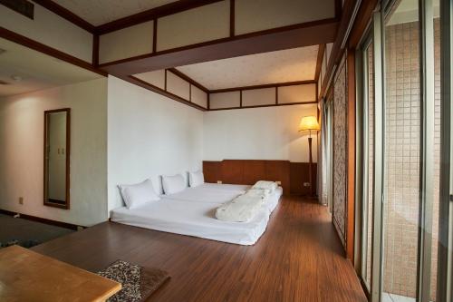 1 dormitorio con 1 cama blanca grande en una habitación en The Glory Hotel, en Luodong
