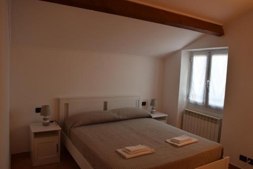 - une chambre avec un lit et 2 serviettes dans l'établissement Ca Rossa vicino al mare nuova e pulita, à Diano Marina