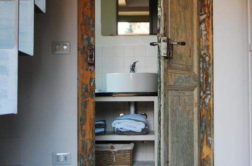 una puerta abierta a un baño con lavabo en Il Bosso del Lago d'Orta en Ameno