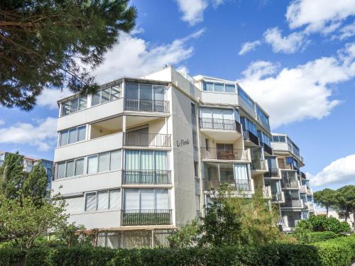 un immeuble d'appartements avec balcon et arbres dans l'établissement Apartment Le Floride-1 by Interhome, au Grau-du-Roi